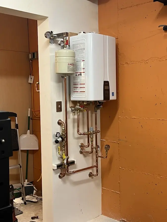 Plumbing technician inspecting water heater connections in Winnfield